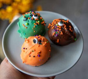 Halloween Oreo Balls by Crumbly Cafe & Bakery NYC featuring chocolate-covered Oreo truffles with spooky Halloween decorations