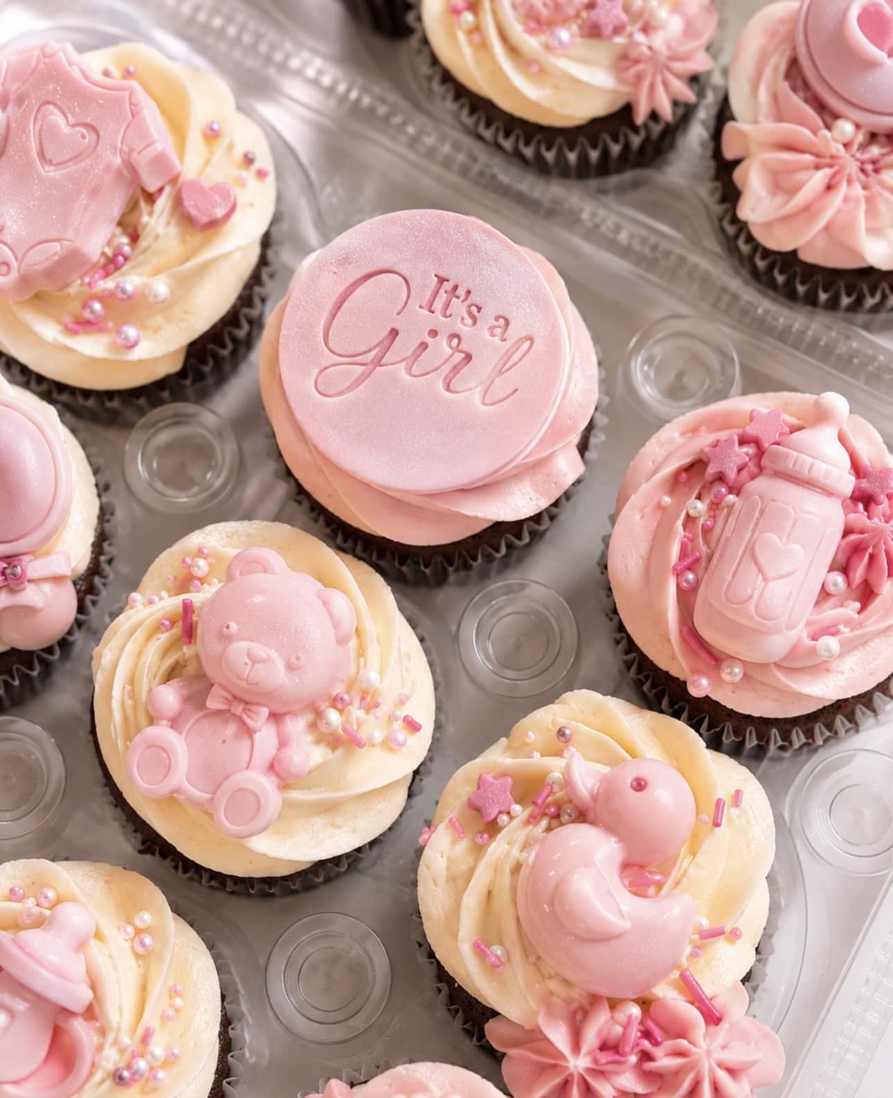 Custom baby shower cupcakes with pastel buttercream, bows, teddy bears, clouds, and themed decorations by Crumbly Cafe & Bakery NYC.