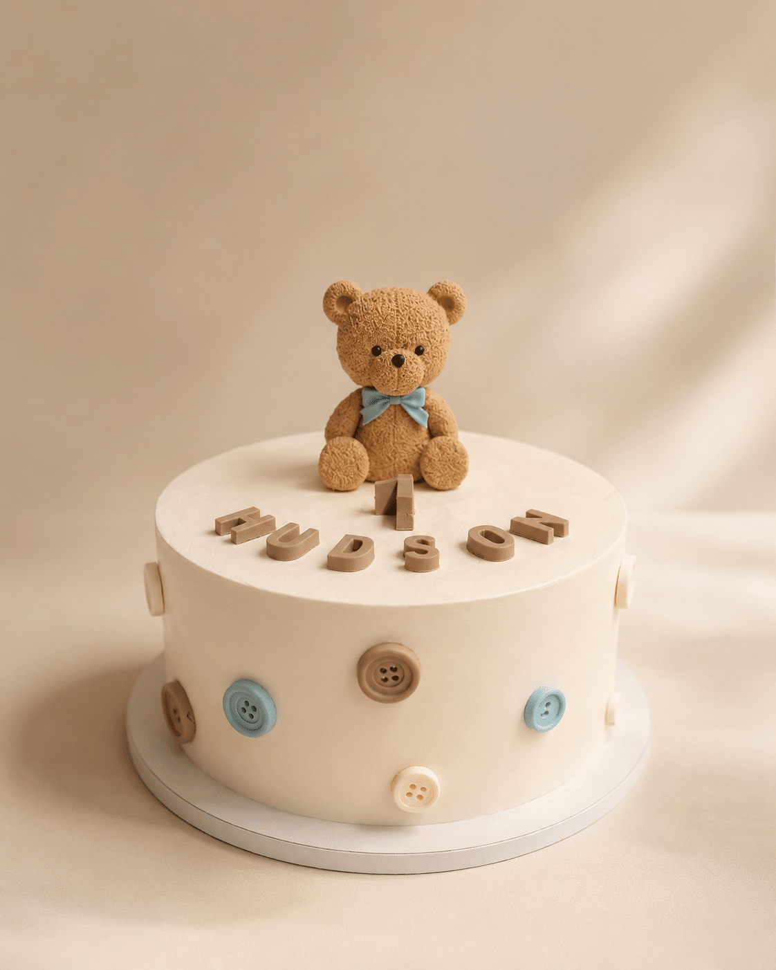 Baby Teddy Bear Cake with teddy bear topper, button details, and soft buttercream finish by Crumbly NYC